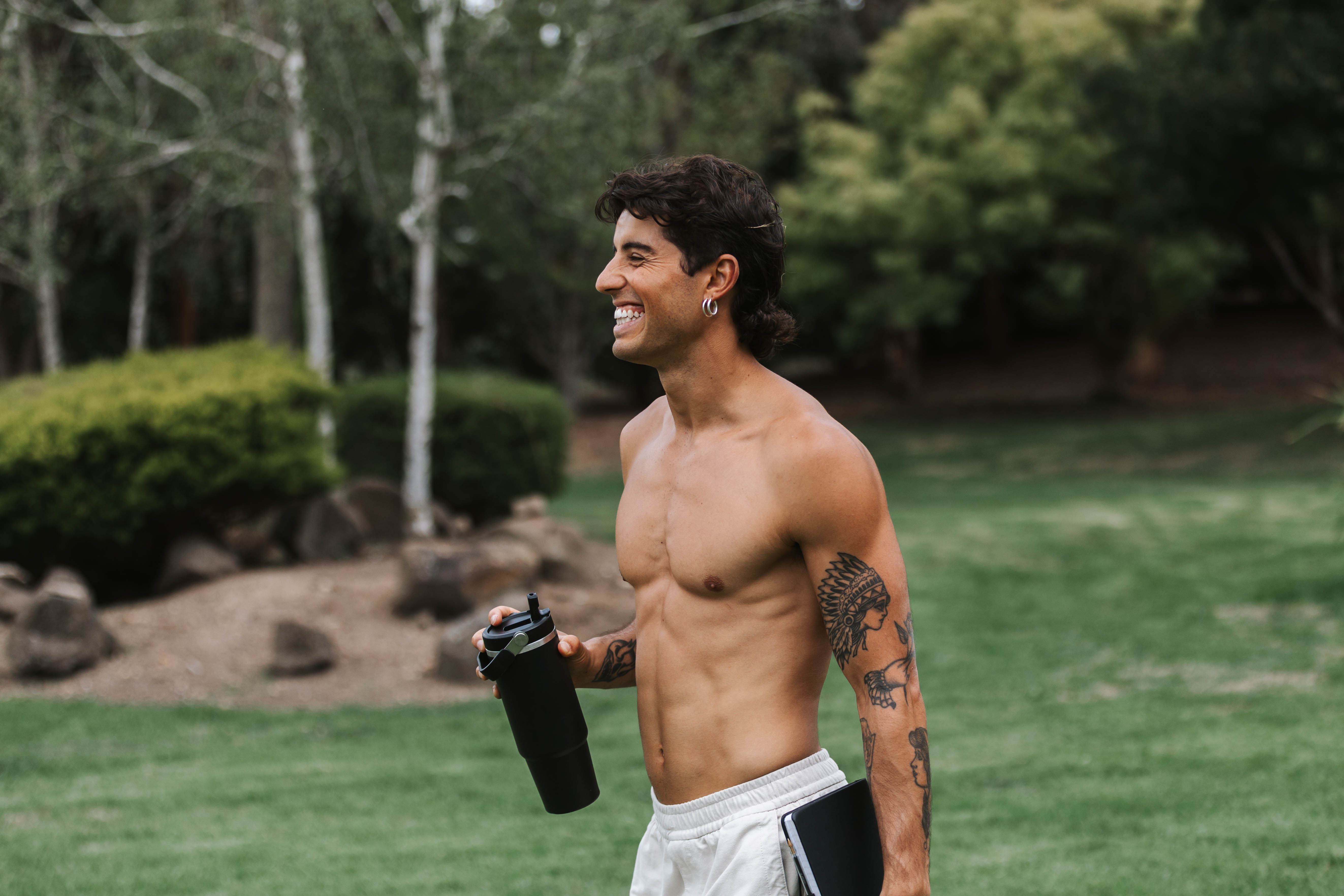 Tristan smiling outdoors with a water bottle — simple, real, grounded living